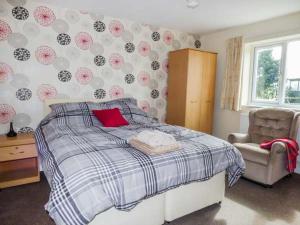 1 dormitorio con 1 cama y 1 silla en The Willows, en Ellesmere