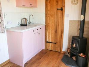 a kitchen with a stove in the corner of a room at Llety'r Bugail in Holyhead