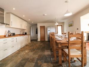 a kitchen and dining room with a table and chairs at Rhos Helyg in Amlwch