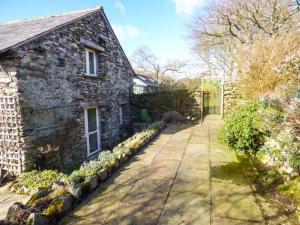 a stone house with a pathway in front of it at Kestrel Cottage in Grange Over Sands +2 photos