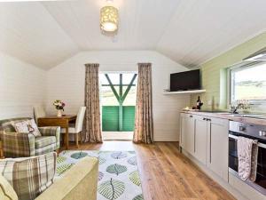 a kitchen and living room with a couch and a table at Ash Lodge in Ulverston