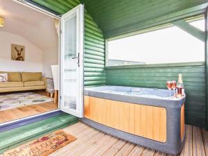 a room with a hot tub in a green room at Ash Lodge in Ulverston