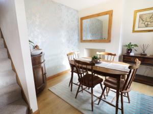 a dining room with a table and chairs and a mirror at 60 Hyfrydle Road in Caernarfon +9 photos