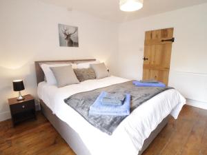 a bedroom with a large white bed with blue towels on it at Minffordd in Bala