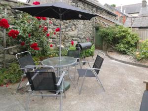 a table and chairs with an umbrella in a garden at Minffordd in Bala