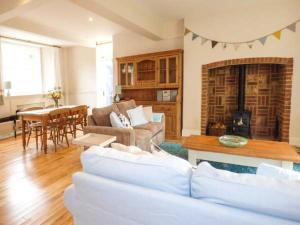 a living room with a couch and a table and a fireplace at East Wing in Crewkerne