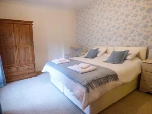 a bedroom with a bed with two towels on it at East Wing in Crewkerne