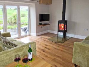 een woonkamer met een bank en een open haard bij Rose Cottage in Grassington