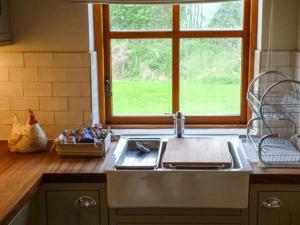 a kitchen with a sink and a window at Stable Cottage in Withernwick