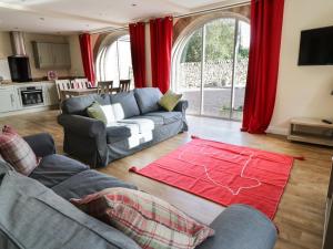 a living room with a couch and a red rug at The Coach House in Settle
