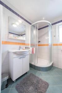a white bathroom with a shower and a sink at Apartment Luna in Srima
