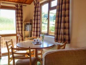a living room with a table and chairs and a window at North Lodge in Staveley