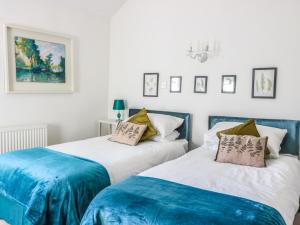 2 Betten in einem blau-weißen Zimmer in der Unterkunft Beulah Cottage in Cinderford