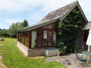 a house with a conservatory with a table and chairs at The Granary in Ross on Wye