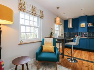 a kitchen with blue walls and a blue chair at The Snug in Grampound