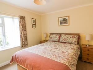 a bedroom with a bed and a window at Polurrian in Helston