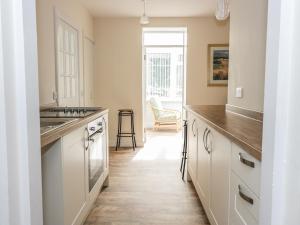 a kitchen with white cabinets and a counter top at East Lodge in Walkerburn