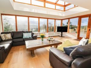 ein Wohnzimmer mit Sofas und einem Couchtisch in der Unterkunft Oakwood House in Saint Harmon