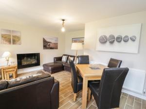 a living room with a table and chairs and a couch at Driftwood in Harlech