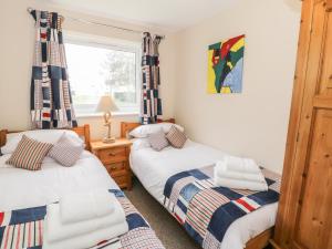 two twin beds in a room with a window at Driftwood in Harlech