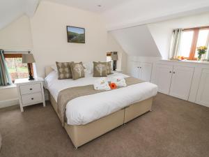 ein Schlafzimmer mit einem Bett mit zwei Stofftieren darauf in der Unterkunft Oakwood House in Saint Harmon