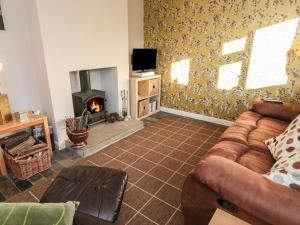 a living room with a couch and a fireplace at Jasmine Cottage in Bakewell
