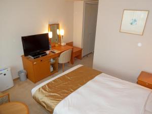 Un pat sau paturi într-o cameră la Kobe Luminous Hotel