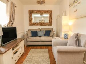 a living room with a couch and a tv at Wren Cottage in Ilfracombe