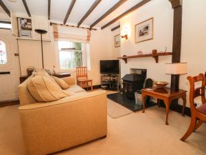 een woonkamer met een bank en een open haard bij Bryn Lleuddad in Llangwnadl