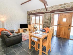 a living room with a table and a couch at Bwthyn Bach in Llanddwywe