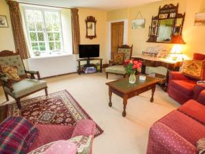 a living room with couches and a table at Mary's Cottage in Kentisbury