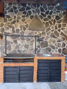 a kitchen with a stone wall and a sink at Cabañas Doña Anita in San Miguel Regla +40 photos