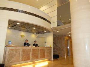 two men standing at a counter in a lobby at Kobe Luminous Hotel in Kobe
