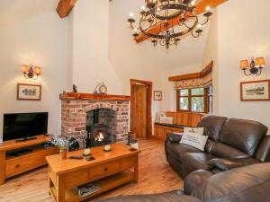 a living room with a couch and a fireplace at Hawthorn Cottage in Sedgwick