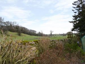 a stone wall with a field in the background at Gardeners Cottage in Hesket Newmarket