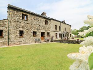 a large stone building with a large yard at Grayrigg Foot Stable in Grayrigg