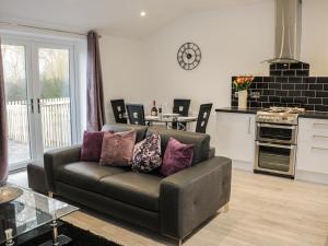 a living room with a couch and a kitchen at Hoden View in Cleeve Prior