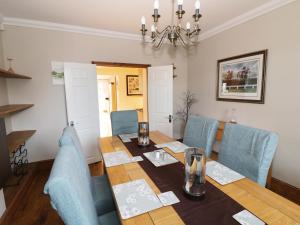 a dining room with a wooden table and blue chairs at Avalon in Stonehouse