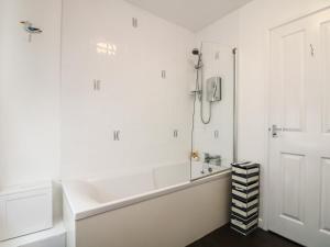 een witte badkamer met een bad en een douche bij Westcliff in Penzance +20 foto's