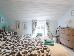 a bedroom with a large bed and a window at Daisy Cottage in Perranporth