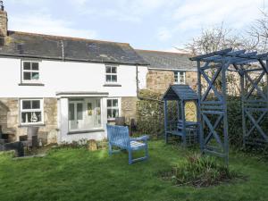 un patio con dos sillas azules frente a una casa en Daisy Cottage en Perranporth