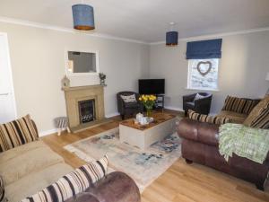 sala de estar con 2 sofás y chimenea en Oakdene en Milford Haven
