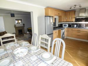 a kitchen with a table and chairs in a kitchen at Oakdene in Milford Haven