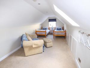 a attic room with a couch and two chairs at Oakdene in Milford Haven