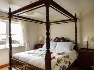 a bedroom with a canopy bed and a window at Bonnie Doon in Kilfearagh
