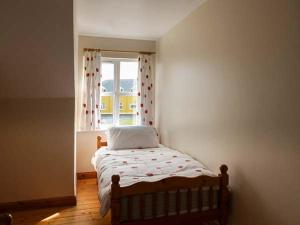 a small bedroom with a bed and a window at Bonnie Doon in Kilfearagh