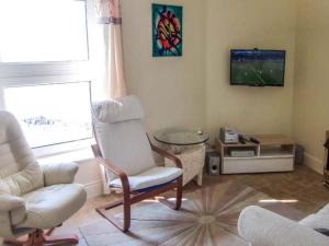 a living room with a chair and a tv at The Beach House Apartment in Buncrana