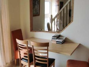 a dining room with a wooden table and two chairs at The Beach House Apartment in Buncrana