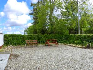 a bench and a picnic table in a park at Ferrys in Portsalon