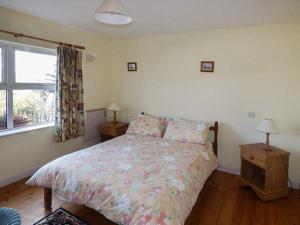 a bedroom with a bed and a window at Number 12 in Mulranny